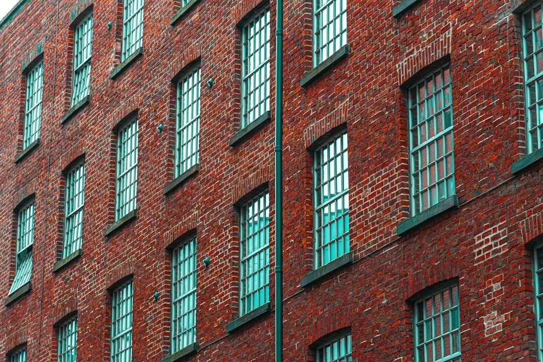 Röd tegelindustribyggnad med många turkosa spröjsade fönster